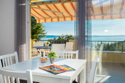 d'une table et de chaises blanches sur un balcon avec vue. dans l'établissement Apartments Maša, à Makarska