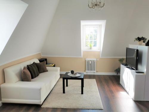 uma sala de estar com um sofá branco e uma mesa em Spilburg Apartments em Wetzlar
