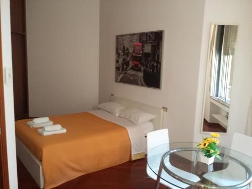 Dormitorio pequeño con cama y mesa de cristal en Appartamento in Centro Milano, en Milán