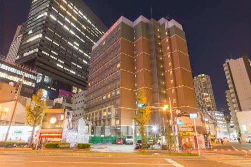 a tall building on a city street at night at Hotel IL Cuore Namba in Osaka