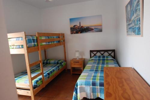 sypialnia z 2 łóżkami piętrowymi i stołem w obiekcie Nice apartment in San José w mieście San José