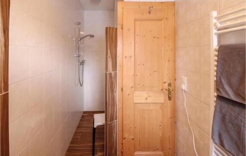 Stunning Apartment In Alpbach With Kitchen في ألباخ: حمام مع دش وباب خشبي