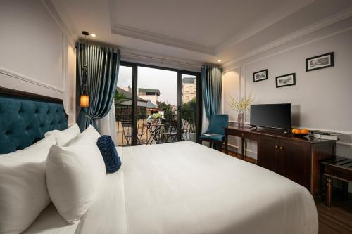 a bedroom with a bed and a desk and a television at Maya Boutique Hotel & Spa in Hanoi