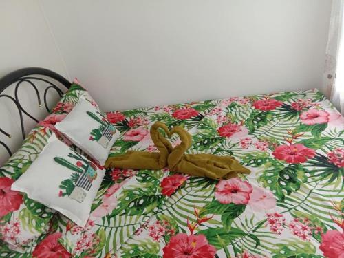 ein Bett mit einer Blumendecke und einem Band darauf in der Unterkunft Heaven Suites, Tagaytay Condominium, Wind Residences in Tagaytay