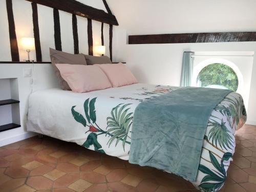 a bedroom with a bed with a tropical print at Les gîtes du Clos Saint-Martin in Maule