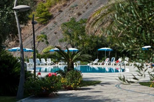 a swimming pool with chairs and umbrellas at Hotel Gabbiano in Maratea