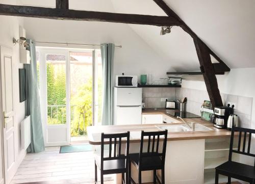 a kitchen with a sink and a counter with chairs at Les gîtes du Clos Saint-Martin in Maule