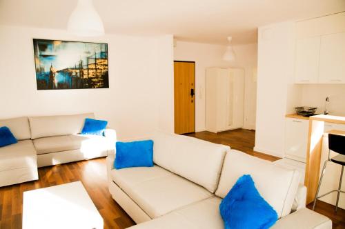 a living room with a white couch and blue pillows at Apartament Blu in Łódź