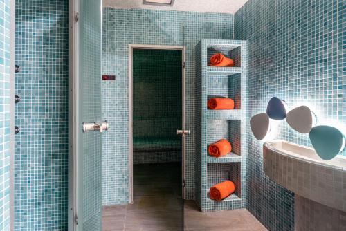 a blue tiled bathroom with a shower and a sink at Elysian Luxury Hotel and Spa in Kalamata
