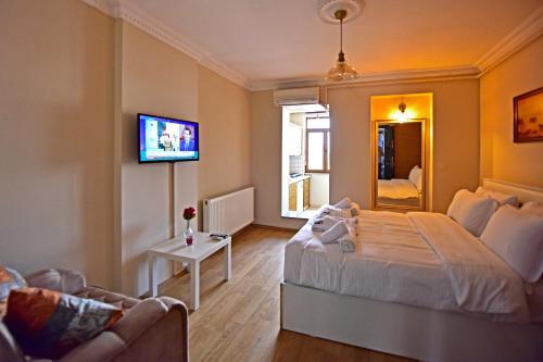 a bedroom with a large bed and a tv on the wall at Sunshine Taksim Suite in Istanbul