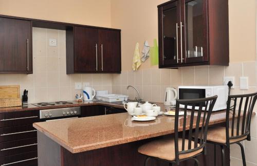 a kitchen with a table with chairs and a microwave at The Lodge at Atlantic Beach in Melkbosstrand
