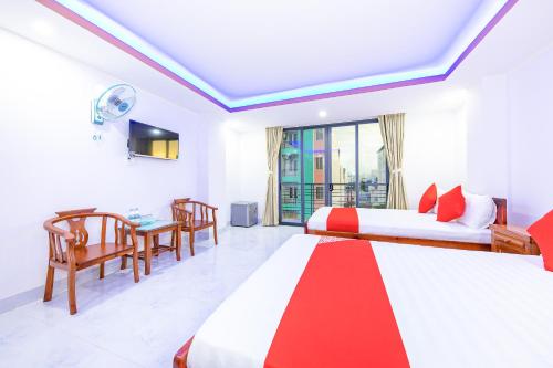 Habitación de hotel con 2 camas y mesa en Q3 Viet An Hotel Nha Trang en Nha Trang