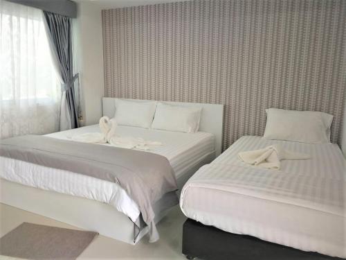 a hotel room with two beds and a window at Phimai Residence in Pi Mai