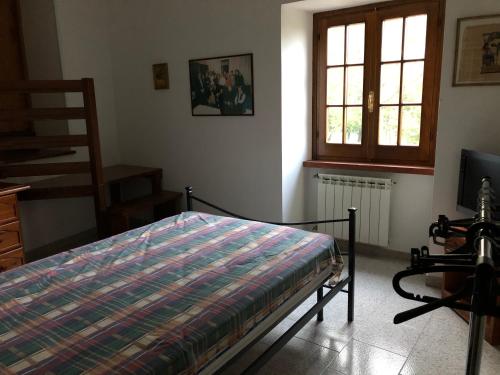 1 dormitorio con 1 cama, TV y ventana en CASCINA NELLA CAMPAGNA ABRUZZESE, en Isola del Gran Sasso dʼItalia