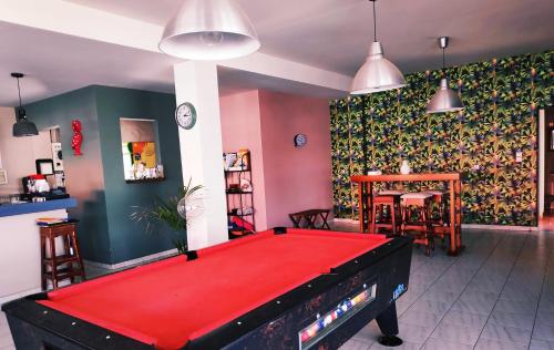 a red pool table in a room with a bar at Ipanema Hotel in Tigaki