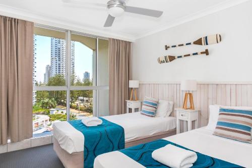 A bed or beds in a room at Golden Sands on the Beach - Absolute Beachfront Apartments