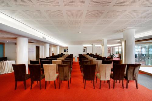 a row of chairs in a room with red carpet at Cocca Hotel Royal Thai Spa in Sarnico