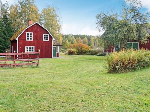 a red barn in the middle of a field at 4 person holiday home in Sk rblacka in Skärblacka