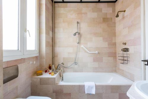 une salle de bain avec une baignoire, une douche et un lavabo dans l'établissement Veeve - Light by Les Halles, à Paris
