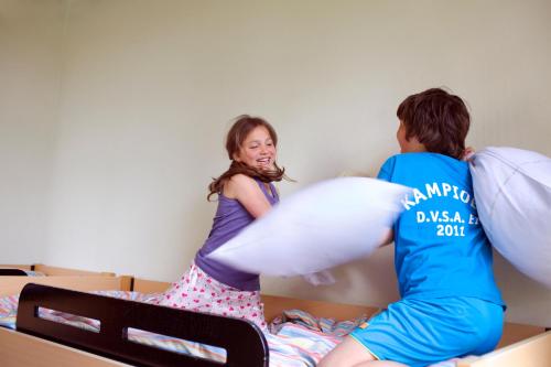 a man and a woman playing with pillows on a bed at Sier aan Zee in Hollum