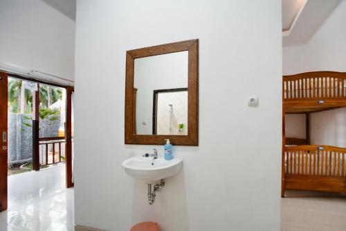 a bathroom with a sink and a mirror on a wall at Double'D Hostel in Nusa Penida