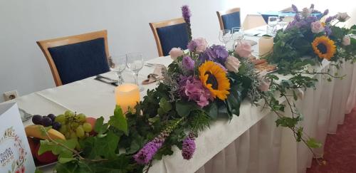 a long table with flowers and candles on it at Iris Hotel in Oradea