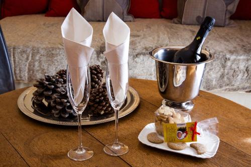 a table with two wine glasses and a plate of food at Paradise Hotel & Wellness in Saint Vincent