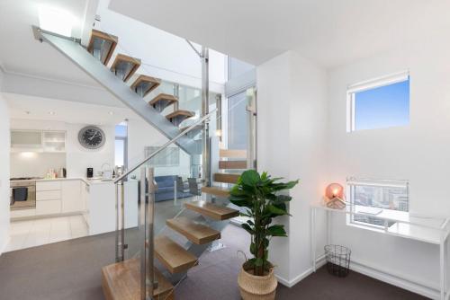a staircase in a home with white walls at SK1 - 2 level 2 Bedroom Skyline SkyHome in Brisbane