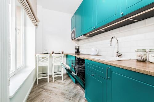 una cocina con armarios azules y fregadero en Apartments Gdańsk Rajska by Renters en Gdansk