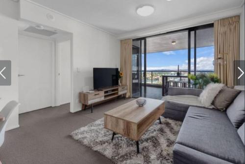 a living room with a couch and a tv at AU1 - Aurora Skyscraper CBD For Business or Pleasure in Brisbane