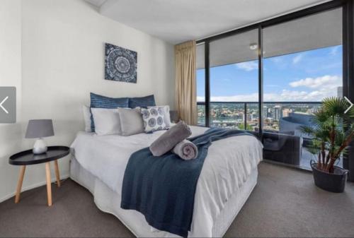a bedroom with a bed and a large window at AU1 - Aurora Skyscraper CBD For Business or Pleasure in Brisbane