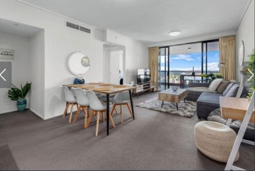 a living room with a table and chairs and a couch at AU1 - Aurora Skyscraper CBD For Business or Pleasure in Brisbane