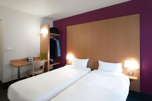 Un pat sau paturi într-o cameră la B&B HOTEL Lyon Eurexpo Chassieu