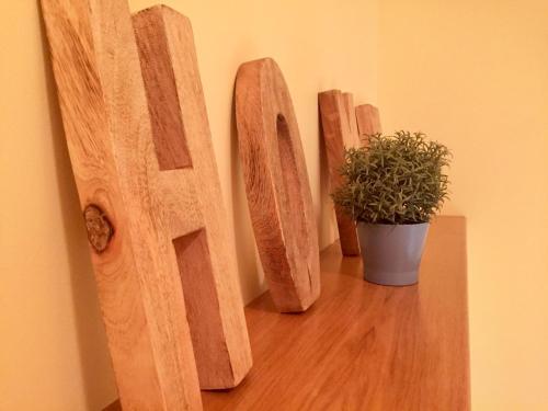 three wooden signs on a wall with a potted plant at Torre Archirafi Vacanze in Riposto