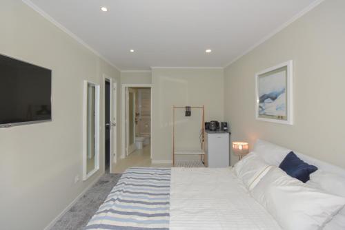 a white bedroom with a bed and a television at Douro Prime Downtown in Vila Nova de Gaia