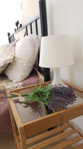 a lamp on a table next to a bed at Theasis House in Khelmáta
