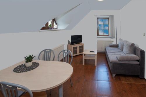 a living room with a table and a couch at Čerti Apartmány in Liberec