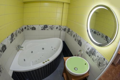 a bathroom with a tub and a sink and a mirror at Čerti Apartmány in Liberec