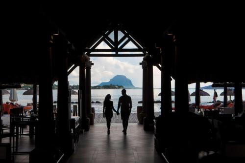 a man and a woman walking down a dock at Sands Suites Resort & Spa in Flic-en-Flac