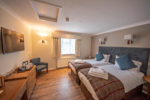 a hotel room with two beds and a television at Norfolk Arms Hotel in Arundel
