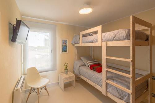 ビニベカにあるBINIPARADISE - Villa Chill Outの二段ベッドとテレビが備わる小さな客室です。