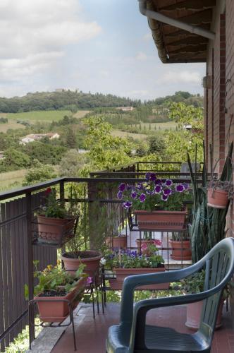 a balcony with plants and chairs and a view at Al centro della Toscana in Poggibonsi
