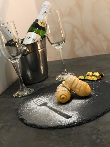 a table with wine glasses and a croissant and a fork at B&B Planet in Montalbano Jonico