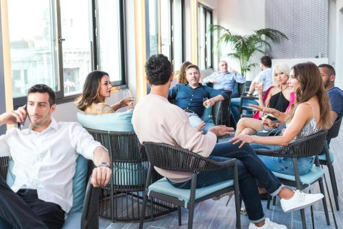 a group of people sitting in chairs in a room at iQ Hotel Milano in Milan