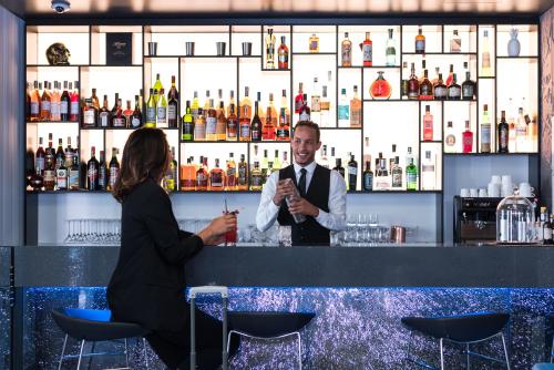 a man and a woman sitting at a bar at iQ Hotel Milano in Milan