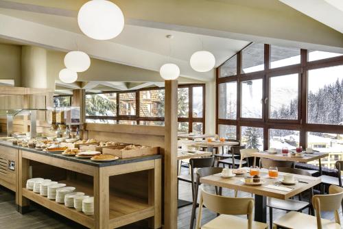 a restaurant with tables and chairs and windows at TH Pila in Pila