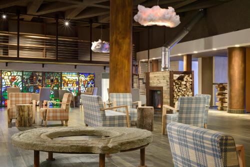 a lobby with chairs and a table and a fire place at TH Pila in Pila