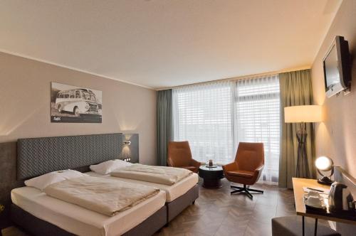 a hotel room with a bed and a window at Arthotel ANA Neotel in Stuttgart