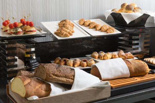 a display case with various types of bread and pastries at iQ Hotel Milano in Milan