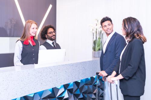 a group of people standing around a counter at iQ Hotel Milano in Milan